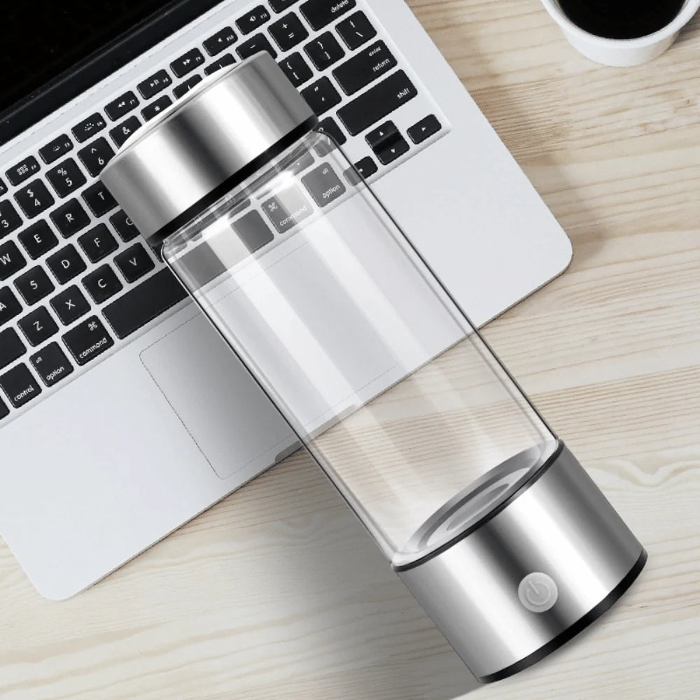 Compact Portable Hydrogen Water Generator bottle beside laptop showing modern lightweight design for travel