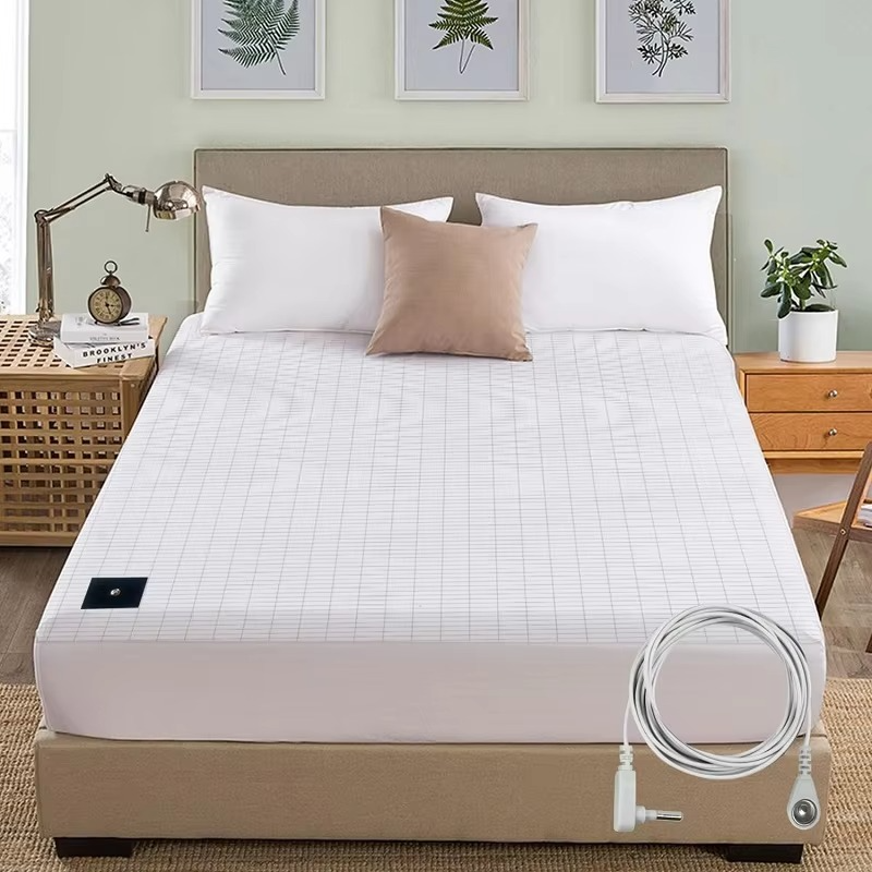 Mattress cover with heating element on a bed in a bedroom setting